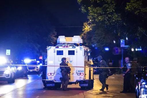 Chicago police and SWAT officers investigate on the 4400 block of West Walton Street where an alleged gunman barricaded himself in a building after one man was killed and three other people were wounded in a shooting in West Humboldt Park on the West Side, Sunday night, May 29, 2022, in Chicago. The suspect also suffered a gunshot wound in the incident, but officers didn't fire any shots, police said. (Ashlee Rezin/Chicago Sun-Times via AP)
