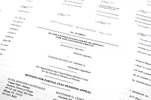 Pages from the Justice Department's motion to the 11th Circuit U.S. Court of Appeals in Atlanta are photographed Friday, Sept. 16, 2022. The Justice Department asked the federal appeals court to lift a judge's order that temporarily barred it from reviewing a batch of classified documents seized during an FBI search of former President Donald Trump's Florida home last month. (AP Photo/Jon Elswick)