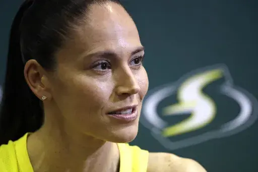 Seattle Storm's Sue Bird talks with media members at the basketball team's media day in Seattle, May 13, 2019. Magic Johnson's love of basketball motivated him to save the Los Angeles Sparks from folding and also put him on the leading edge of what is now a growing WNBA trend. Former WNBA players Sue Bird and Renee Montgomery have joined the ownership groups of the Seattle Storm and Atlanta Dream, respectively. (AP Photo/Elaine Thompson, File)