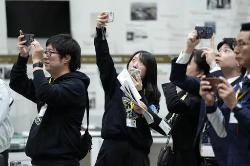 Staff of Japan Aerospace Exploration Agency (JAXA) watch a live streaming of the pinpoint moon landing operation by the Smart Lander for Investigating Moon (SLIM) spacecraft observe a live streaming at JAXA's Sagamihara Campus Saturday, Jan. 20, 2024, in Sagamihara near Tokyo. Japan's space agency said early Saturday that its spacecraft is on the moon, but is still "checking its status." More details will be given at a news conference, officials said. (AP Photo/Eugene Hoshiko)