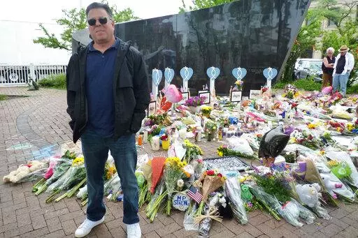 Bobby Shapiro of Highland Park, Ill., stands on Friday, July 8, 2022, for a photo at a memorial for victims of the Highland Park mass shooting that occurred during a parade on Monday, July 4, 2022. “It was pure horror. It was a battle zone,” Shapiro, 52, said in an interview. (AP Photo/Roger Schneider)