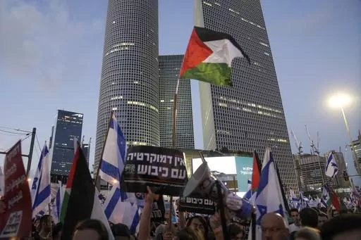 Demonstrators wave the Israeli and Palestinian flags during a protest against plans by Prime Minister Benjamin Netanyahu's government to overhaul the judicial system, in Tel Aviv, Israel, Saturday, July 22, 2023. Israel is being rocked by a wave of mass protests calling to uphold the country’s democracy. But the cries for democracy lack any clear message of opposition to Israel’s rule over millions of Palestinians, exposing a contradiction that has been coursing through the demonstrations. (