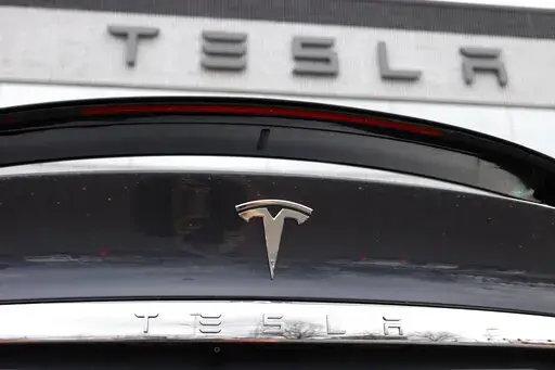In this April 26, 2020 photo, the company logo shines off the rear deck of an unsold 2020 Model X at a Tesla dealership in Littleton, Colo. Tesla’s sales from April through June 2022 fell to their lowest quarterly level since last fall as supply chain issues and pandemic restrictions in China hobbled production of its electric vehicles. (AP Photo/David Zalubowski, File)