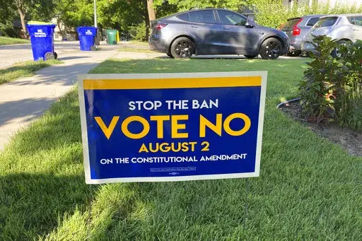 In this photo from Thursday, July 14, 2022, a sign in a yard in Merriam, Kansas, urges voters to oppose a proposed amendment to the Kansas Constitution to allow legislators to further restrict or ban abortion.  The day before Kansas voters rejected a ballot question that could have eroded abortion rights, many reported receiving anonymous text messages with misleading information about the vote.  (AP Photo/John Hanna)