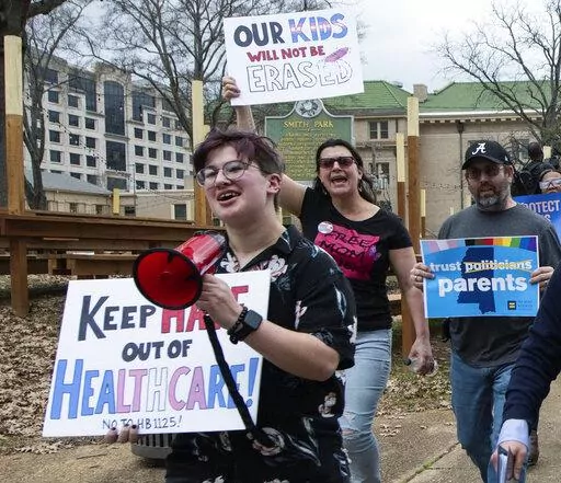 Leviathan Myers-Rowell, 16, from left, of Ocean Springs, Miss., and his parents Jodi and Thomas Rowell march from the state Capitol toward the governor's mansion following a rally at the Capitol in support of transgender youth and in opposition to House Bill 1125 in Jackson, Miss., Wednesday, Feb. 15, 2022. HB 1125 prohibits transgender-related healthcare in Mississippi for people under the age of 18. (Barbara Gauntt//The Clarion-Ledger via AP)