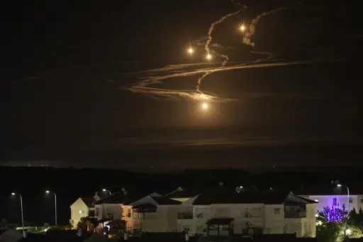 Flares rise over the Gaza Strip as seen from southern Israel, Monday, Jan. 8, 2024. (AP Photo/Leo Correa)