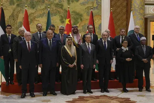 Chinese Foreign Minister Wang Yi, foreground center, stands with his counterparts from left, Palestine Foreign Minister Riyad al-Maliki, Egyptian Foreign Minister Sameh Shoukry, Saudi Arabia's Foreign Minister Faisal bin Farhan Al Saud, Jordanian Deputy Prime Minister and Foreign Minister Ayman Safadi, Indonesian Foreign Minister Retno Marsudi, Secretary-General of the Organization of Islamic Cooperation (OIC) Hissein Brahim Taha and their delegations as they pose for a group photo prior to thei