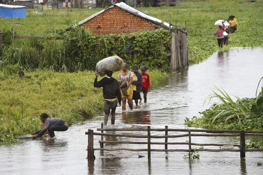 Residents wade through flood water around their homes after heavy rain in Antananarivo, on Jan. 19, 2022. Rich countries say they will spend about $25 billion by 2025 to boost Africa’s efforts to adapt to climate change as the continent continues to struggle with drought, cyclones and extreme heat, according to officials at a summit in Rotterdam in the Netherlands. (AP Photo/Alexander Joe, File)