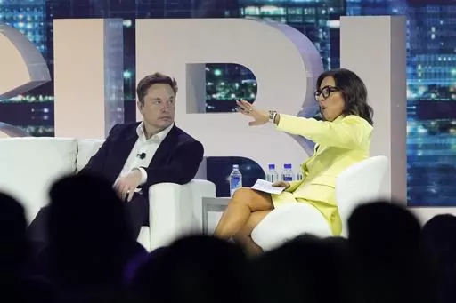 Twitter CEO Elon Musk, center, speaks with Linda Yaccarino, chairman of global advertising and partnerships for NBC, at the POSSIBLE marketing conference, Tuesday, April 18, 2023, in Miami Beach, Fla. Musk announced Friday, May 12, 2023, that he's hiring Yaccarino to be the new CEO of San Francisco-based Twitter, which is now called X Corp. (AP Photo/Rebecca Blackwell, File)