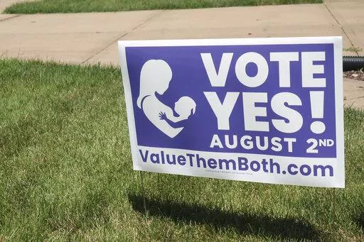 In this photo from Friday, July 8, 2022, a sign in a yard in Olathe, Kansas, promotes a proposed amendment to the Kansas Constitution to allow legislators to further restrict or ban abortion. Supporters call the measure "Value Them Both," arguing that it protects both unborn children and the women carrying them. Alabama, Arizona, Georgia, Kansas and Missouri all have personhood laws. (AP Photo/John Hanna, File)