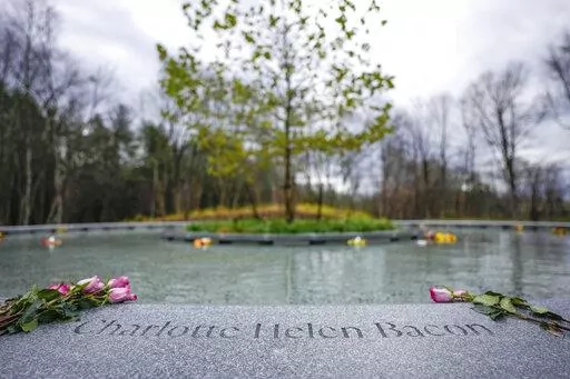 Flowers lay next to the name of Charlotte Bacon, carved in the stone of a memorial dedicated to the victims of the Sandy Hook Elementary School shooting, in Newtown, Conn., Sunday, Nov. 13, 2022. (AP Photo/Bryan Woolston)
