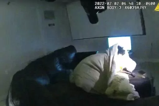 In this image taken from Minneapolis Police Department body camera video and released by the city of Minneapolis, 22-year-old Amir Locke wrapped in a blanket on a couch holding a gun moments before he was fatally shot by Minneapolis police as they were executing a search warrant in a homicide investigation on Wednesday, Feb. 2, 2022, in Minneapolis. Authorities have not said if Locke was connected to the homicide investigation or named in the warrant. (Minneapolis Police Department via AP)