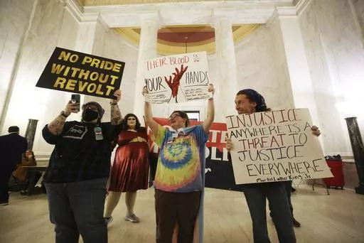 Protestors hold signs during a rally opposing HB2007 at the state capitol in Charleston, W.Va., on March 9, 2023. HB2007 would ban health care for trans children in the state. (AP Photo/Chris Jackson)