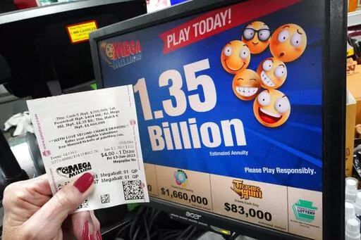 A customer at the Cranberry Super Mini Mart in Cranberry, Pa., shows her Mega Millions ticket on Thursday, Jan. 12, 2023. (AP Photo/Gene J. Puskar)