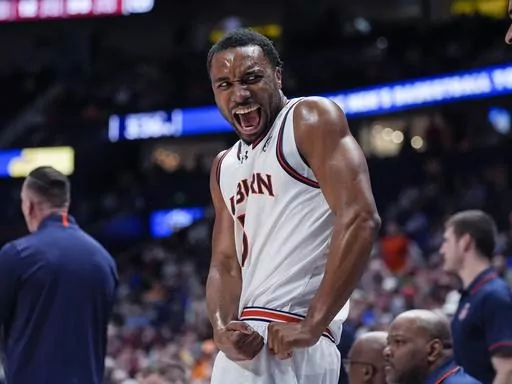 Auburn forward Chris Moore reacts on the bench after a Tiger's basket during the first half of an NCAA college basketball game against South Carolina at the Southeastern Conference tournament Friday, March 15, 2024, in Nashville, Tenn. (AP Photo/John Bazemore)