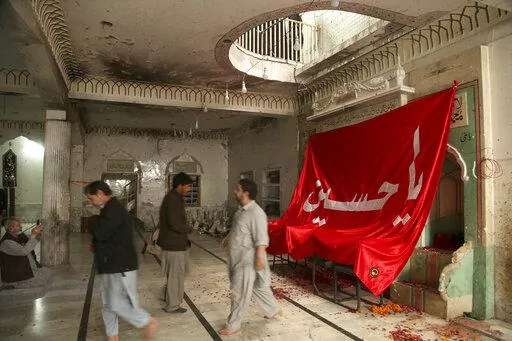 People visit Kusha Kisaldar Shiite Mosque, the site of March 4 suicide bombing, to offer prays for bombing victims, in Peshawar, Pakistan, Wednesday, March 9, 2022. In northwest Pakistan the remains of an IS suicide bomber are still visible on the once ornate walls of a mosque where last month more than 63 worshippers died as they knelt in prayer. The bomber, an Afghan identified by IS as Julaybib al-Kabuli, was from the capital Kabul. (AP Photo/Muhammad Sajjad)
