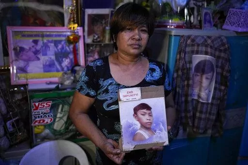Emily Soriano holds a picture of her 15-year-old son as she recounts how he was gunned down with four friends and two other residents while partying in a Philippine slum six years ago during an interview with the Associated Press at their home in Manila, Philippines on June 23, 2022. With Philippine President Rodrigo Duterte set to step down on June 30, 2022 at the end of his turbulent six-year term, Soriano and other relatives, who say their loved ones were victims of extrajudicial killings und