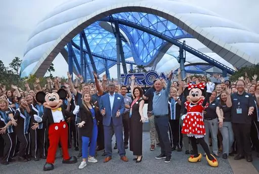 Mickey, Minnie and cast members join Walt Disney World executives in a ceremony marking the official opening of Tron Lightcycle / Run at the Magic Kingdom in Lake Buena Vista, Fla., on Monday, April 3, 2023. The roller coaster opens to guests on Tuesday. From left are Mickey Mouse; Ali Manion, Walt Disney World ambassador; Perry Crawley, Magic Kingdom operations general manager; Melissa Valiquette, vice president of Magic Kingdom; Jason Kirk, senior vice president of operations for Walt Disney W