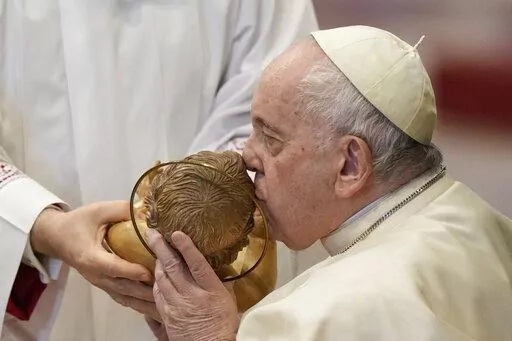 Pope Francis kisses a statue of Baby Jesus as he attends a Mass for the solemnity of St. Mary at the beginning of the new year, in St. Peter's Basilica at the Vatican, Sunday, Jan. 1, 2023. Pope Emeritus Benedict XVI, the German theologian who will be remembered as the first pope in 600 years to resign, has died, the Vatican announced Saturday. He was 95. (AP Photo/Andrew Medichini)