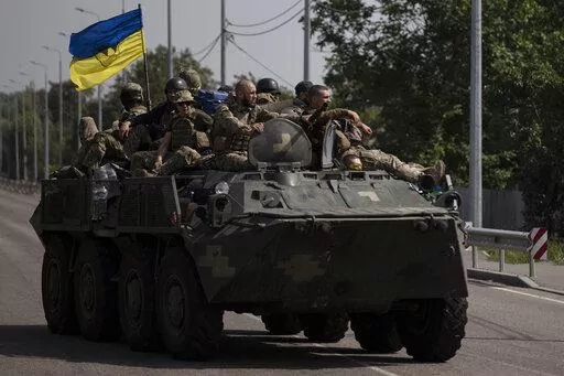 Ukrainian servicemen ride atop of an armored vehicle on a road in Donetsk region, eastern Ukraine, Sunday, Aug. 28, 2022. As the war slogs on, a growing flow of Western weapons over the summer is now playing a key role in the counteroffensive, helping Ukraine significantly boost its precision strike capability. (AP Photo/Leo Correa, File)