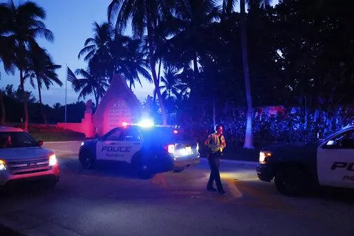Police direct traffic outside an entrance to former President Donald Trump's Mar-a-Lago estate, Monday, Aug. 8, 2022, in Palm Beach, Fla. Trump said in a lengthy statement that the FBI was conducting a search of his Mar-a-Lago estate and asserted that agents had broken open a safe. (AP Photo/Terry Renna)