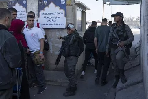 Israeli border police officers check identification cards of Palestinians while they try to cross from the occupied West Bank into Jerusalem, to pray during the holiest night of Ramadan, Laylat al-Qadr, or the "Night of Destiny," when Muslims believe that the Quran was revealed to the Prophet Mohammad, in the Al Aqsa mosque compound, at the Israeli military Qalandiya checkpoint, near Ramallah, Monday, April 17, 2023. Hundreds of thousands of Palestinians are barred from legally crossing into the