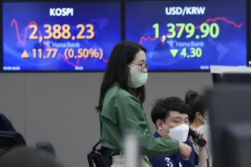 A currency trader watches monitors in front of screens showing the Korea Composite Stock Price Index (KOSPI), left, and the exchange rate of South Korean won against the U.S. dollar, at the foreign exchange dealing room of the KEB Hana Bank headquarters in Seoul, South Korea, Thursday, Sept. 8, 2022. Asian benchmarks mostly rose Thursday, as investor optimism got a perk from a rally on Wall Street that's on track to break a three-week losing streak. (AP Photo/Ahn Young-joon)