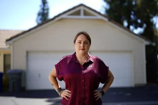 Kate Needham, a veteran who co-founded the nonprofit Armed Forces Housing Advocates, looks on in a housing complex, Tuesday, Aug. 16, 2022, in San Diego. Needham's group supplies microgrants to military families in need, some of whom have resorted to food banks because their salaries do not cover such basics. “I don’t think civilians really understand — they might think we’re living in free housing and just having a great time, making lots of money. And that’s not the case at all.” (