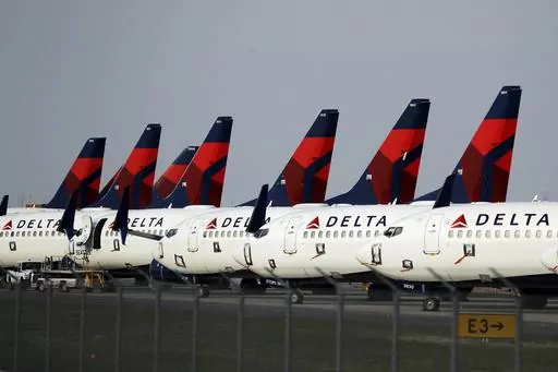 In this April 1, 2020, file photo, several dozen Delta Air Lines jets are parked at Kansas City International Airport in Kansas City, Mo. Delta is backtracking slightly on changes it previously announced in its frequent-flyer program, but it still plans to reshape SkyMiles to favor big spenders over customers who take the most flights. Delta outlined the revisions in an email from CEO Ed Bastian to SkyMiles members on Wednesday, Oct. 18, 2023. (AP Photo/Charlie Riedel, File)