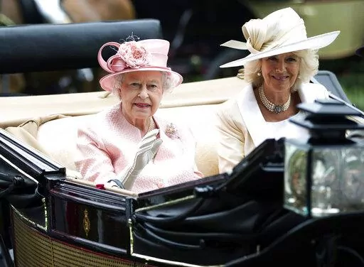 Britain's Queen Elizabeth II waves to the crowds with Camilla, Duchess of Cornwall  at right, as they arrive by carriage on the first day of the Royal Ascot horse race meeting in Ascot, England, Tuesday, June 18, 2013.  Queen Elizabeth II has offered her support to have the Duchess of Cornwall become Queen Camilla — using a special Platinum Jubilee message to make a significant decision in shaping the future of the monarchy. (AP Photo/Alastair Grant, File)