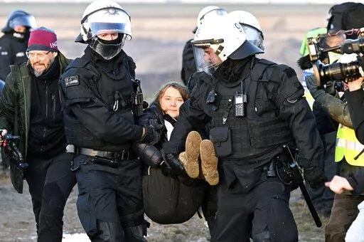 Police officers carry Swedish climate activist Greta Thunberg away from the edge of the Garzweiler II opencast lignite mine during a protest action by climate activists after the clearance of Luetzerath, Germany, Tuesday, Jan. 17, 2023. After the eviction of Luetzerath ended on Sunday, coal opponents continued their protests on Tuesday at several locations in North Rhine-Westphalia. (Federico Gambarini/dpa via AP)