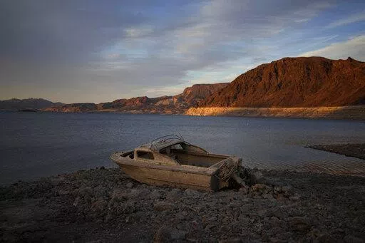 A formerly sunken boat sits high and dry along the shoreline of Lake Mead at the Lake Mead National Recreation Area, on May 10, 2022, near Boulder City, Nev. Another body has surfaced at Lake Mead, this time in a swimming area where water levels have dropped as the Colorado River reservoir behind Hoover Dam recedes due to drought and climate change. The National Park Service did not say in a statement how long officials think the corpse was submerged in the Boulder Beach area before it was found