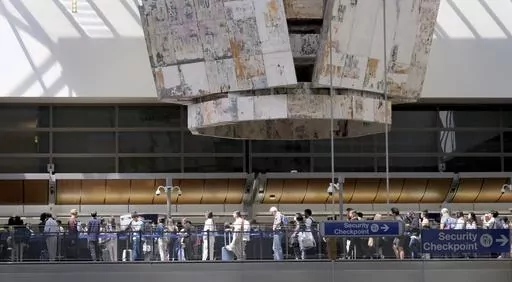 Travelers stand in line at the Tom Bradley International Terminal at LAX on Wednesday, Aug. 30, 2023, in Los Angeles. With Labor Day weekend just days away, airports and roadways are expected to be busy as tens of thousands of Southern Californians travel out of town. (Dean Musgrove/The Orange County Register via AP)