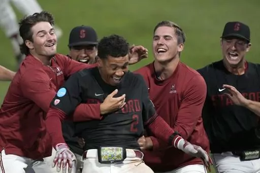 Stanford's Drew Bowser (2) celebrates with teammates after hitting a single to score the winning run against Texas in the ninth inning of an NCAA college baseball tournament super regional game in Stanford, Calif., Monday, June 12, 2023. Stanford won 7-6. (AP Photo/Tony Avelar)