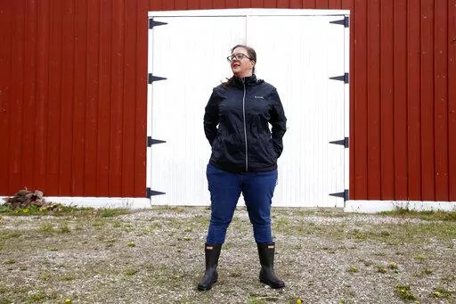 Alison Dreith stands in front of her barn in southern Illinois on Wednesday, April 13, 2022. Dreith works remotely for the Midwest Access Coalition, which pays for "practical support" for women seeking abortions. That includes things like air fare, gas money, hotel rooms or child care. Says Dreith, "I'm kind of a freak out first, calm down later kind of person is the big energy I have. So I really appreciate that I have something — no pun intended — like, really practical to do." (AP Photo/M
