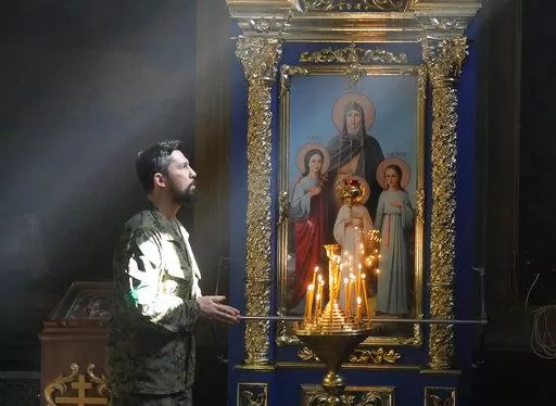 A Ukrainian soldier prays in St. Michael Cathedral during Easter celebration in Kyiv, Ukraine, Sunday, April 24, 2022. (AP Photo/Efrem Lukatsky)