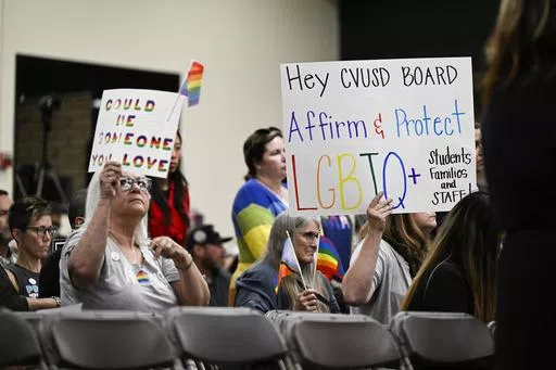 Parents, students, and staff of Chino Valley Unified School District hold up signs in favor of protecting LGBTQ+ policies at Don Antonio Lugo High School, June 15, 2023, in Chino, Calif. Californians won't be voting this November on a policy that would have required schools to notify parents if their child asks to change their gender identification. Proponents of a ballot measure to create such a statewide policy announced Tuesday, May 28, 2024, that they failed to collect enough signatures to p