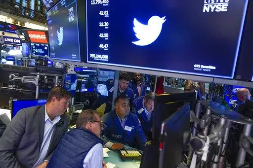 Traders gather around a post as Twitter shares resume trading on the floor at the New York Stock Exchange in New York, Tuesday, Oct. 4, 2022. (AP Photo/Seth Wenig)