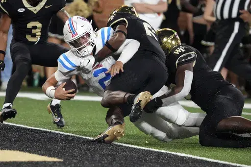 Mississippi quarterback Jaxson Dart (2) stretches in for a touchdown against Wake Forest defensive back Rushaun Tongue (6) during the second half of an NCAA college football game in Winston-Salem, N.C., Saturday, Sept. 14, 2024. (AP Photo/Chuck Burton)