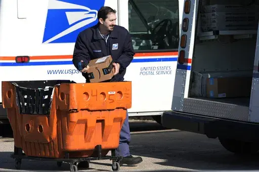 A U.S. Postal Service employee loads parcels outside a post office in Wheeling, Ill., on Jan. 29, 2024. (AP Photo/Nam Y. Huh, File)