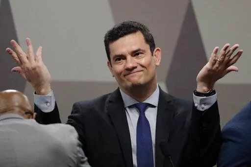 Brazil's Justice Minister Sergio Moro throws his hands up as he arrives to testify before a Senate commission, in Brasilia, Brazil, Wednesday, June 19, 2019. When Moro resigned to enter politics, many in Brazil believed the anti-corruption crusader who jailed da Silva could someday occupy the nation’s most powerful office. But on the eve of Brazil’s Oct. 2, 2022 general election, the once-revered magistrate was fighting what polls showed was a losing battle for a Senate seat. (AP Photo/Erald