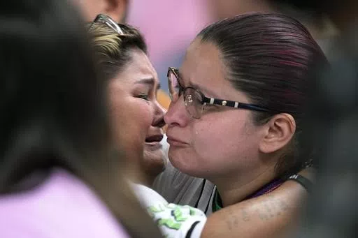 Felicia Martinez, left, and Evadulia Orta, right, both whose children were among 19 children killed in the massacre at Robb Elementary, embrace after speaking at a special city council meeting in Uvalde, Texas, Thursday, March 7, 2024. Almost two years after the deadly school shooting in Uvalde that left 19 children and two teachers dead, the city council met to discuss the results of an independent investigation it requested into the response by local police officers. (AP Photo/Eric Gay)