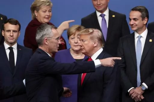 NATO Secretary-General Jens Stoltenberg, front center left, speaks with U.S. President Donald Trump, front center right, after a group photo at a NATO leaders meeting at The Grove hotel and resort in Watford, Hertfordshire, England, Dec. 4, 2019. As Trump becomes the first former president to face federal charges that could put him in jail, many Europeans are watching the case closely. But hardly a single world leader has said a word recently about the man leading the race for the Republican par