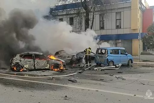 In this photo taken from video released by Russian Emergency Situations Ministry Telegram channel on Dec. 30, 2023, firefighters extinguish burning cars after shelling in Belgorod, Russia. The attack in the city near the border with Ukraine killed 25 people and injured 109, dealing a heavy blow to President Vladimir Putin's attempts to reassure his countrymen that their lives have been largely unchanged by the nearly two-year military operation. (Russia Emergency Situations Ministry Telegram cha