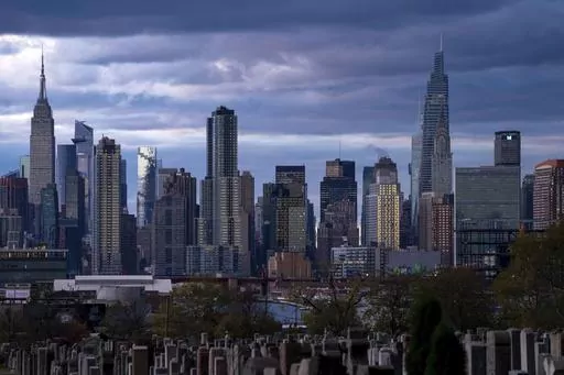 The sun sets behind the New York skyline, Nov. 13, 2022, as seen from Calvary Cemetery. New York City appears to have gotten an additional 1,090 people added to its population total recently after asking the Census Bureau to double-check the city's numbers from the head count of every U.S. resident, city officials said. (AP Photo/Julia Nikhinson, File)