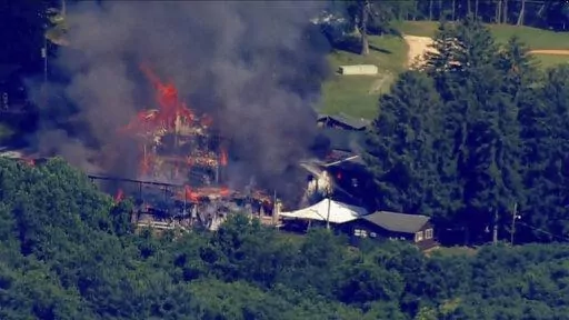 This image taken from video provided by WJLA shows crews battling a fire at Camp Airy for Boys in Thurmont, Md., on Wednesday, June 29, 2022. The building was empty when the fire broke out and no injuries have been reported, Frederick County Division of Fire & Rescue Services spokesperson Sarah Campbell said.  Residents and campers were not in the area of the fire, she said.   (WJLA via AP)
