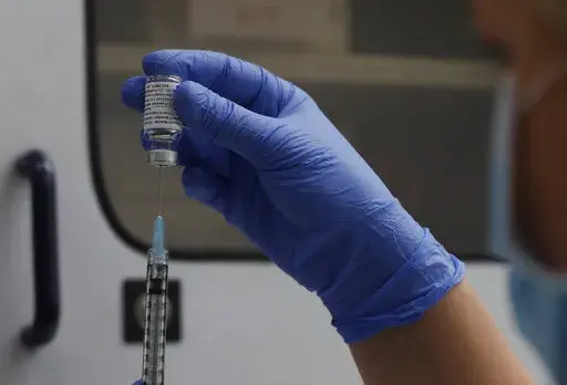 A vial of the Phase 3 Novavax coronavirus vaccine is seen ready for use in the trial at St. George's University hospital in London, Oct. 7, 2020. The Novavax COVID-19 vaccine that could soon win federal approval may offer a boost for the U.S. military: an opportunity to get shots into some of the thousands of service members who have refused the vaccine for religious reasons. (AP Photo/Alastair Grant, File)