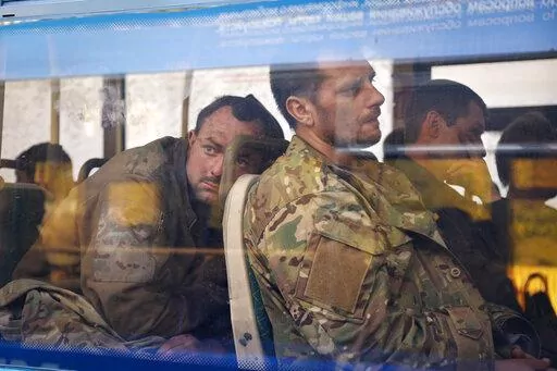Ukrainian servicemen sit in a bus after they were evacuated from the besieged Mariupol's Azovstal steel plant, near a remand prison in Olyonivka, in territory under the government of the Donetsk People's Republic, eastern Ukraine, Tuesday, May 17, 2022. Breaking its silence on prisoners of war, the Red Cross said Thursday, May 19, 2022 it has registered “hundreds” of Ukrainian prisoners of war who left the giant Azovstal steel plant in Mariupol after holding out in a weeks-long standoff with