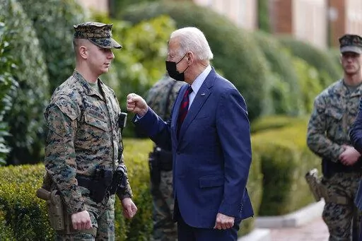 President Joe Biden visits a marine outside the Marine Barracks Washington, Tuesday, Jan. 25, 2022, in Washington. (AP Photo/Andrew Harnik)