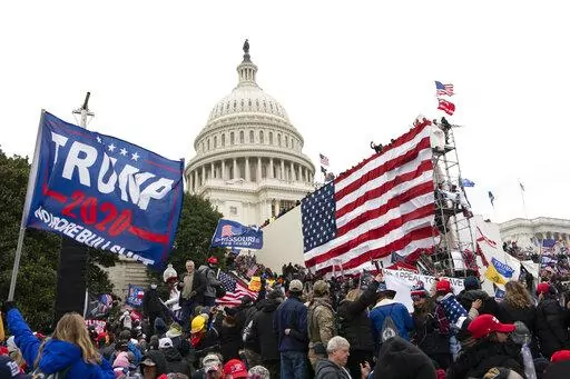 Rioters stand outside the U.S. Capitol in Washington, on Jan. 6, 2021.  A new poll shows that about half of Americans say former President Donald Trump should be charged with a crime for his role in what happened on Jan. 6. The Associated Press-NORC Center for Public Affairs Research poll found that 48% of U.S. adults believe Trump should be held accountable for what happened during the deadly Capitol attack.(AP Photo/Jose Luis Magana, File)